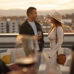 people drinking wine on a rooftop at dusk